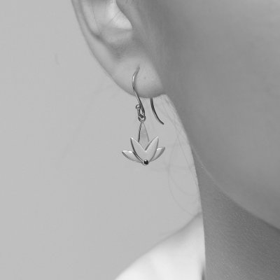 Kvinde brer n Lotus rering i rhodineret sterlingslv med sort cubic zirconia – stylet med blankpoleret finish og karakterfuldt udtryk, der fremhver kollektionens symbolske elegance.