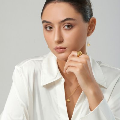 Profil af kvinde med to forskellige Lotus reringe – n i forgyldt sterlingslv med kde og n i rhodineret slv uden kde – stylet med sort cubic zirconia.